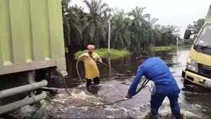 Aksi Sigap Polisi Pelalawan Evakuasi Mobil Boks Terperosok Air Banjir