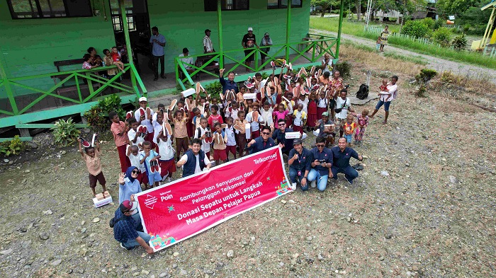 Telkomsel serahkan ratusan pasang sepatu yang merupakan hasil donasi penukaran Telkomsel Poin pelanggan ke sejumlah pelajar di Papua