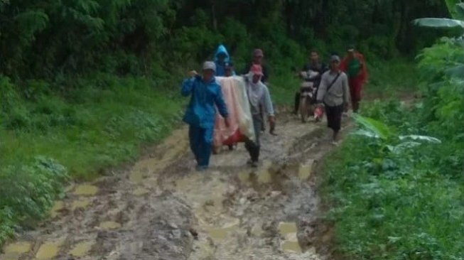 Bukan Hoaks, Seorang Pasien  Puskesmas Terpaksa Ditandu karena Jalan Rusak Parah