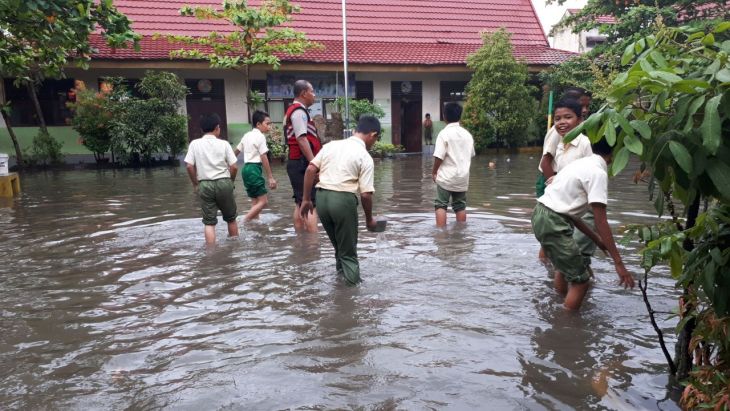 Bhabinkamtibmas Bantu Siswa Bersihkan Banjir di SDN 142 Pekanbaru